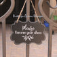 Black laminate scalloped edge sign with white lettering stating Please remove your shoes with leaf design and border on outdoor gate