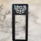 Black laminate doorbell surround with white lettering stating Welcome-ish Depends on who you are and what you want with 2 leaf designs on marble background