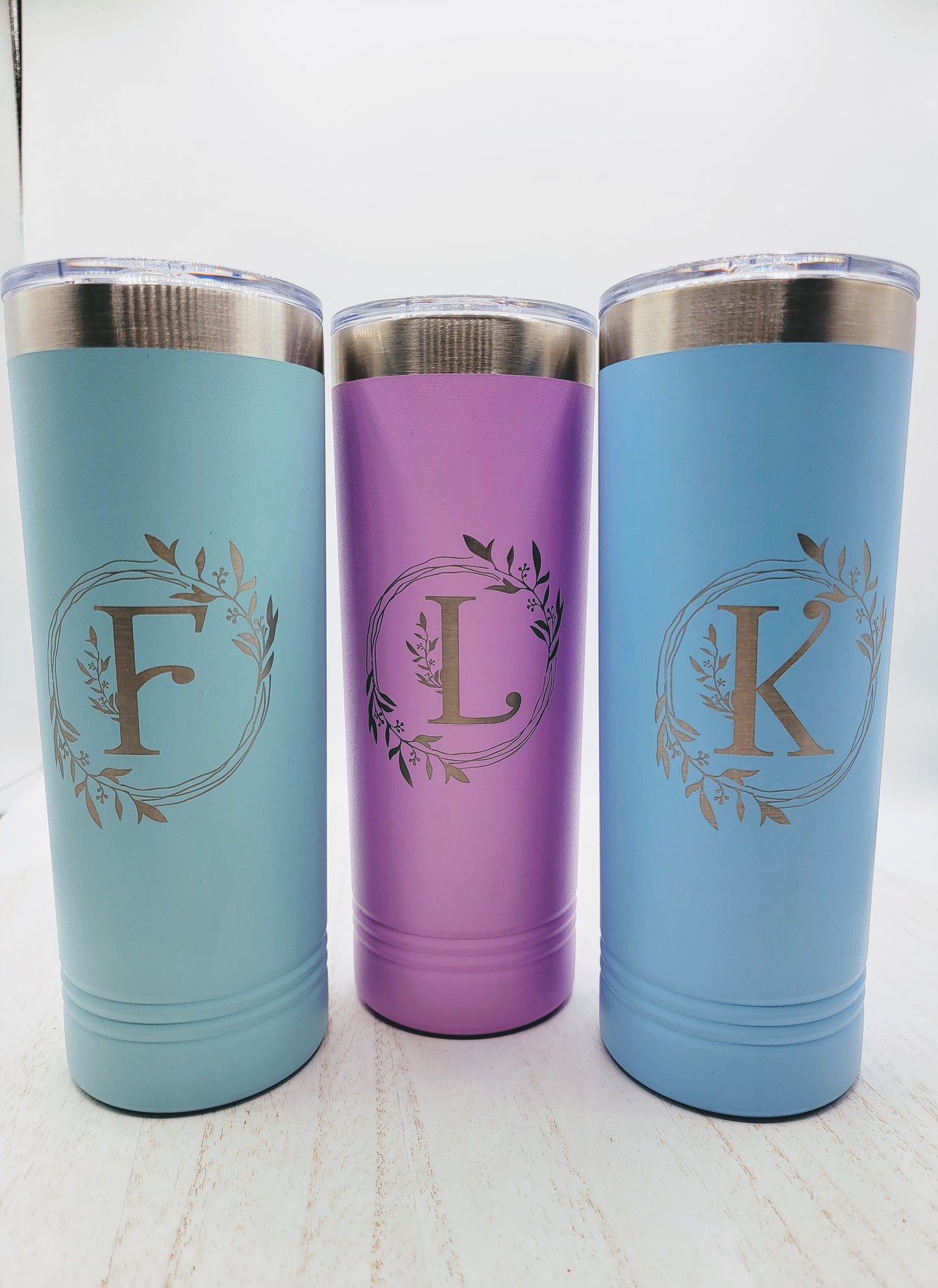 3 skinny tumblers in teal, light purple, and light blue on white background