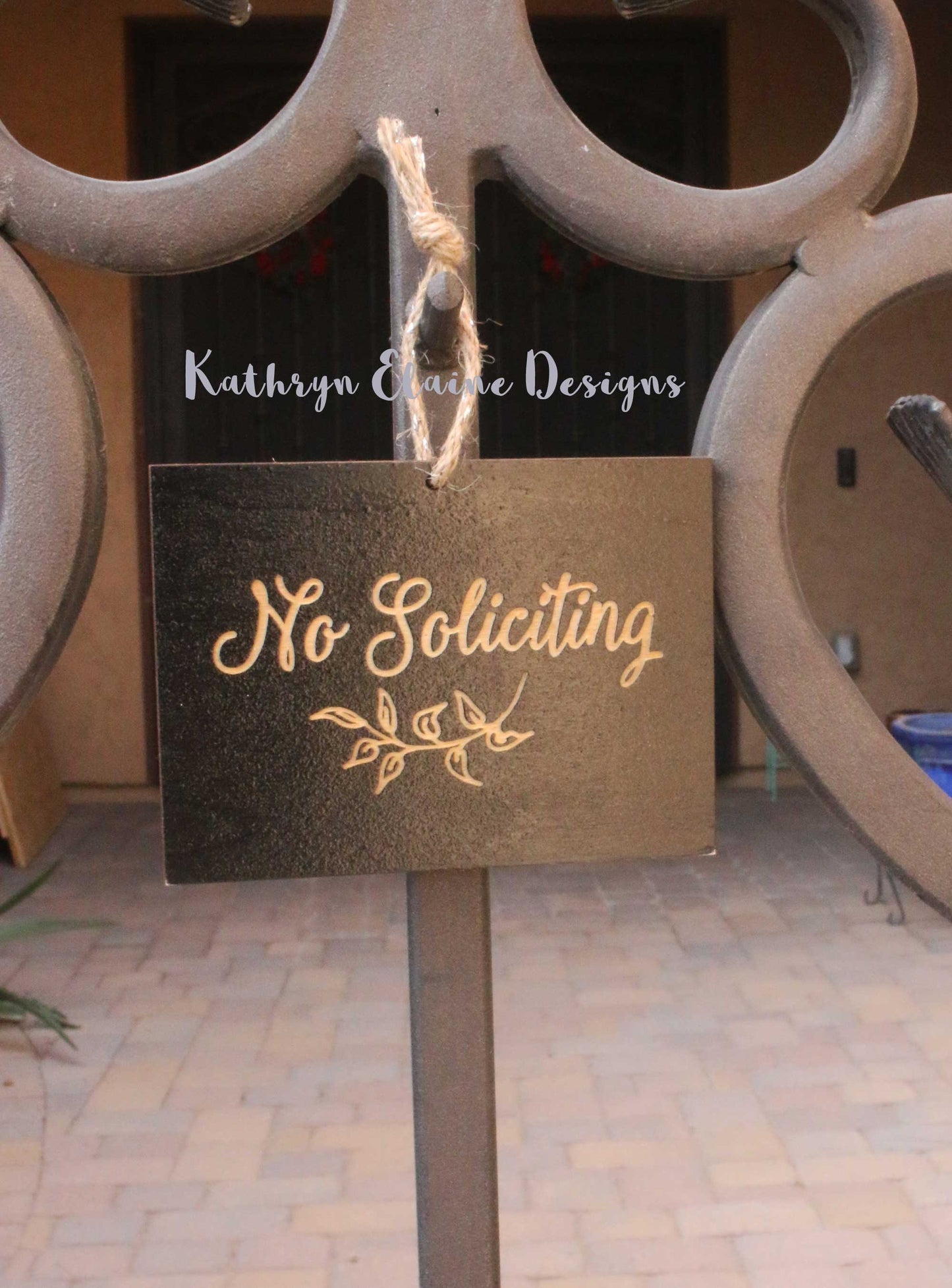 Black rectangle laser engrave no soliciting sign with leaf design and twine hanger on gate