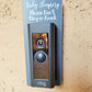 Gray laminate rectangle around Ring doorbell that says Baby Sleeping Please Don't Ring or Knock in white lettering against tan stucco background