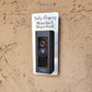 Silver laminate rectangle around Ring doorbell that says Baby Sleeping Please Don't Ring or Knock in black lettering against tan stucco background