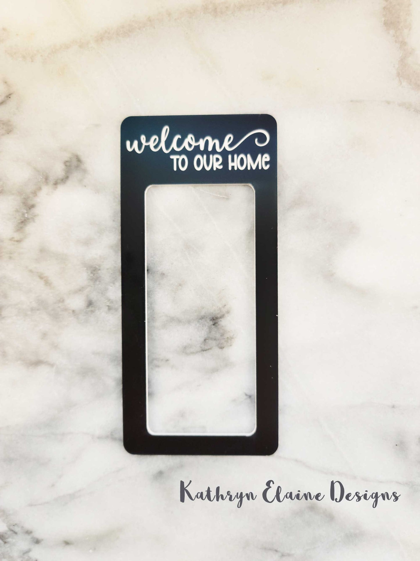 Black laminate doorbell surround stating Welcome to our home in white lettering on marble background