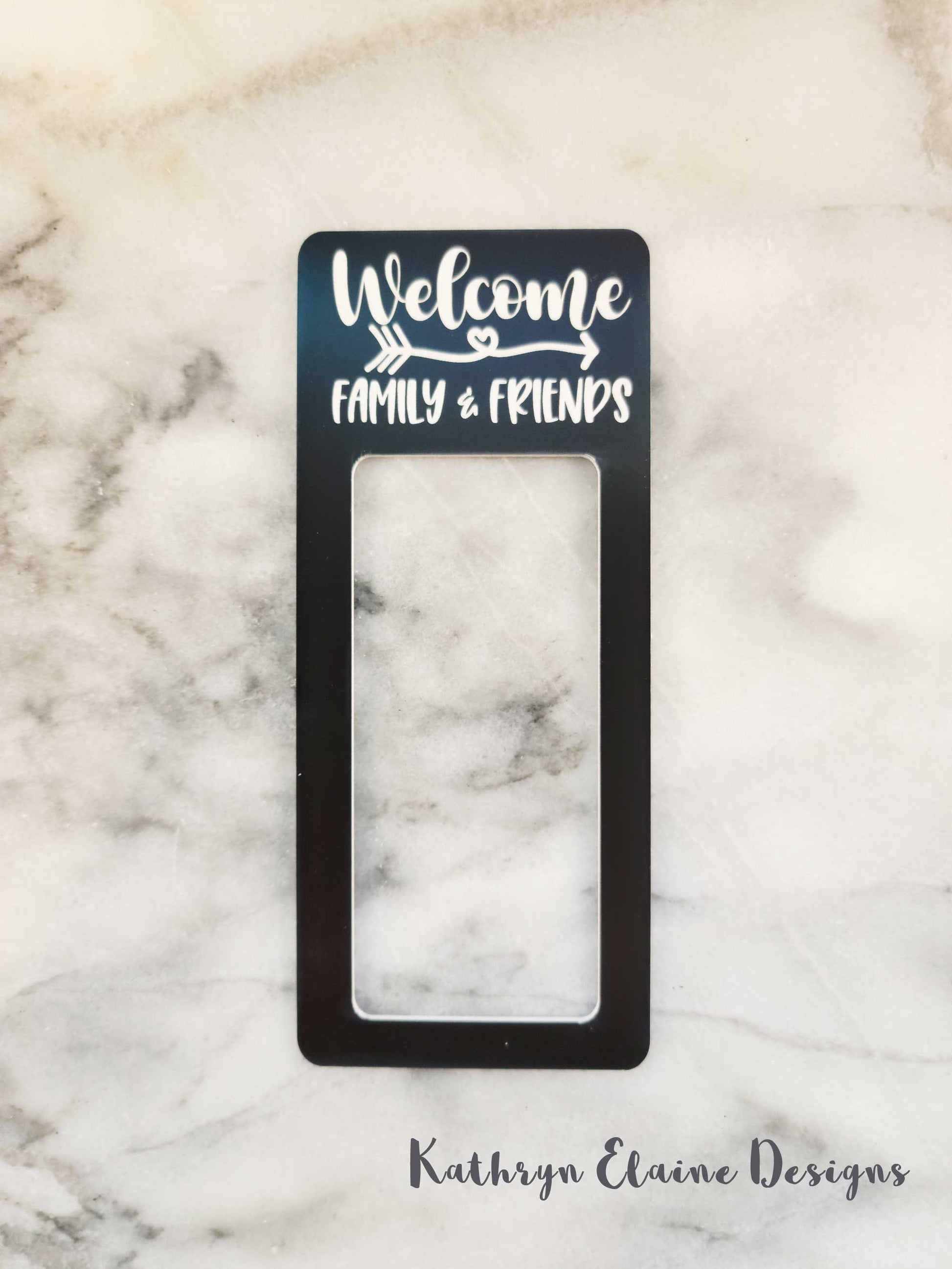 Black laminate doorbell surround with white lettering stating Welcome arrow design family and friends around on marble background